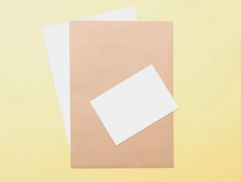 Composition with brown and white blank sheets on yellow background Stock Photos