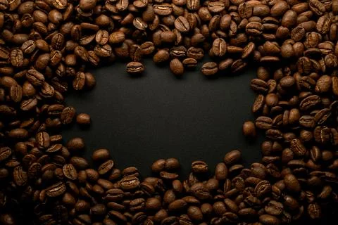 Composition of brown roasted coffee beans on black surface. Can be used as Stock Photos