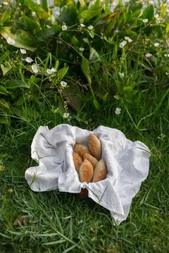 Composition of buns in basket with white white cloth napkin on the green grass Stock Photos