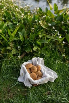Composition of buns in basket with white white cloth napkin on the green grass Stock Photos