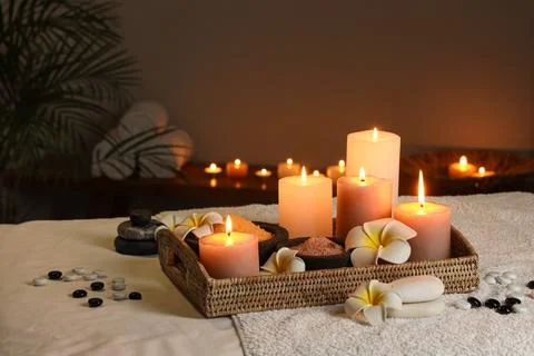 Composition with burning candles, spa stones, bowls of sea salt and flowers o Stock Photos