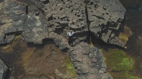 The composition of the camera flying down to a young girl resting on a reef. The Stock Footage 146964445