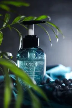 Composition of a can of conditioner with berries and a plant on a fabric Stock Photos