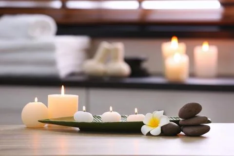 Composition with candles and stones on table in spa salon. Space for text 스톡 사진