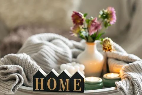Composition with candles, flowers and decorative word home. Stock Photos