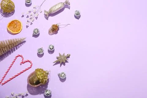 Composition with candy canes, disco balls and Christmas decor on lilac backgr Stock Photos