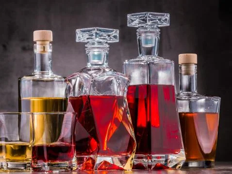 Composition with carafe and bottles of assorted alcoholic beverages. Stock Photos