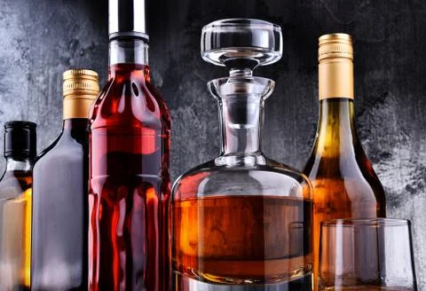 Composition with carafe and bottles of assorted alcoholic beverages. Stock Photos