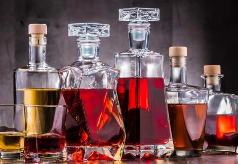 Composition with carafe and bottles of assorted alcoholic beverages. Stock Photos