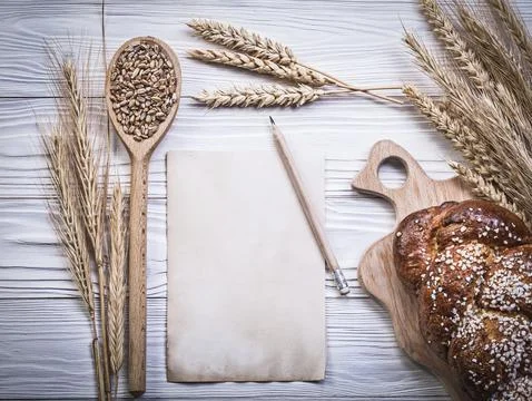 Composition of carving board wheat-rye ears baked bread stick wooden spoon grain 스톡 사진