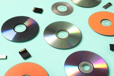 Composition with CD disks, USB flash drives and SD cards on turquoise backgro Stock Photos