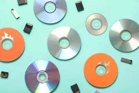 Composition with CD disks, USB flash drives and SD cards on turquoise backgro Stock Photos