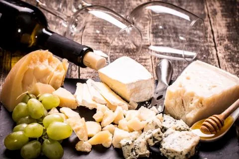 Composition of cheese, berries, bottles and glasses of wine on a wooden table Stock Photos