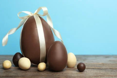 Composition with chocolate Easter eggs on table against color background. Spa Stock Photos