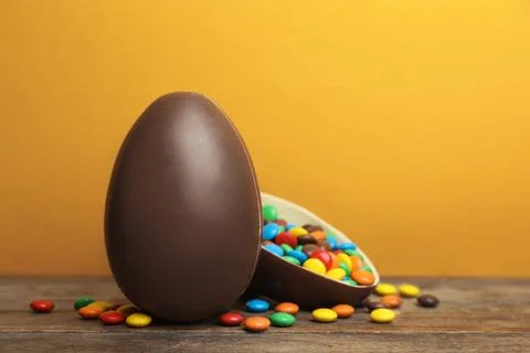 Composition with chocolate Easter eggs on table against color background. Spa Stock Photos