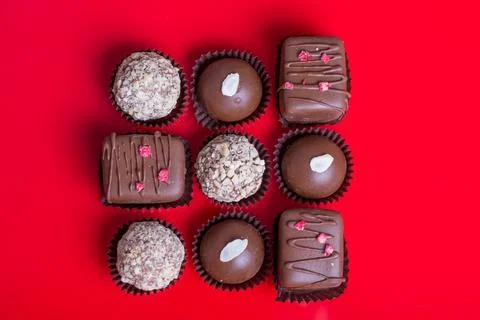 Composition of chocolate, red background Stock Photos