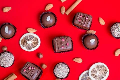 Composition of chocolate, red background Stock Photos