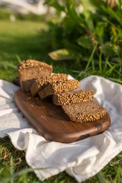 Composition of chopped homemade custard bread on wood board on the green grass Stock Photos