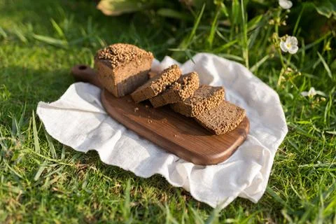 Composition of chopped homemade custard bread on wood board on the green grass Stock Photos