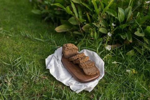 Composition of chopped homemade custard bread on wood board on the green grass Stock-Fotos