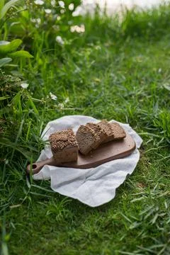 Composition of chopped homemade custard bread on wood board on the green grass Stock Photos