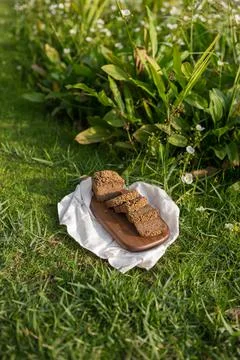 Composition of chopped homemade custard bread on wood board on the green grass Stock Photos