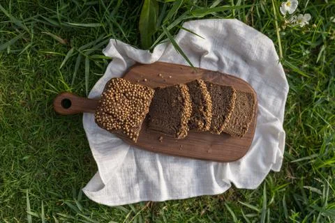Composition of chopped homemade custard bread on wood board on the green grass Stock Photos