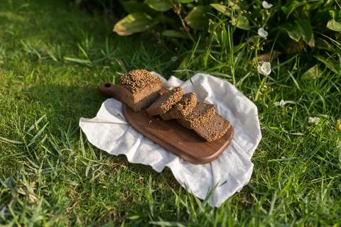 Composition of chopped homemade custard bread on wood board on the green grass Stock Photos