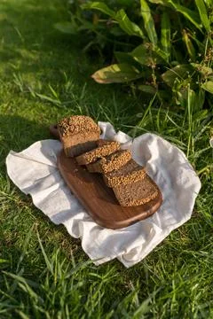 Composition of chopped homemade custard bread on wood board on the green grass Stock Photos