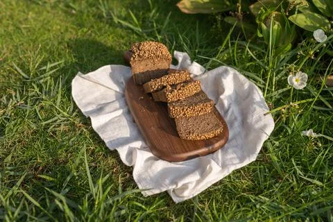 Composition of chopped homemade custard bread on wood board on the green grass Stock Photos