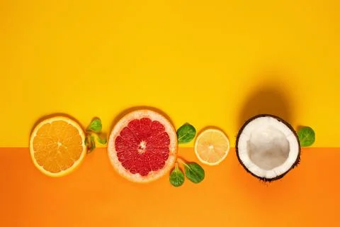Composition of citrus fruit, orange, lemon and coconut on yellow background 写真素材