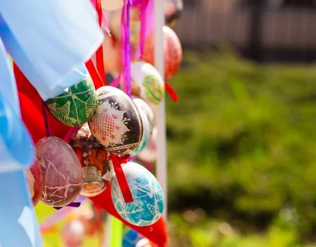 A composition of colorful Easter eggs handing with the multi colored ribbons. Stock Photos