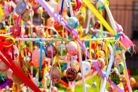 A composition of colorful Easter eggs handing with the multi colored ribbons. Stock Photos