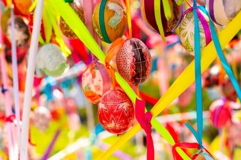 A composition of colorful Easter eggs handing with the multi colored ribbons. Stock Photos