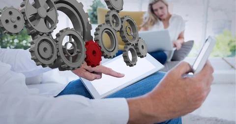 Composition of connected 3d cogs over man and woman in office using tablet, Stock Photos
