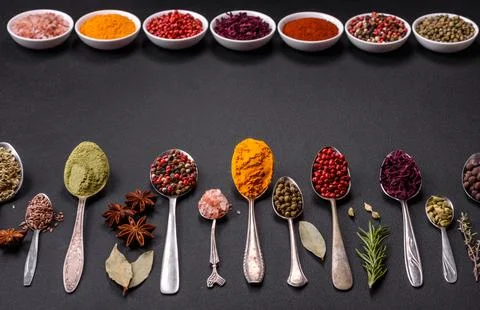 Composition consisting of variations of spices in white bowls and metal spoon Stock Photos