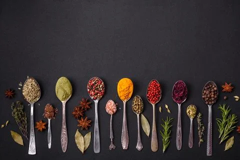 Composition consisting of variations of spices in white bowls and metal spoon Stock Photos