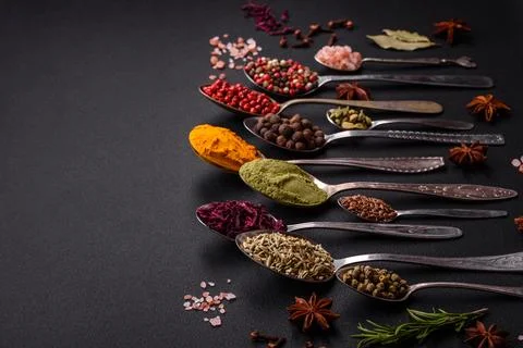 Composition consisting of variations of spices in white bowls and metal spoon Stock Photos