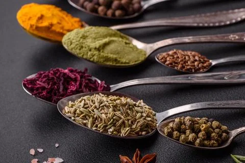 Composition consisting of variations of spices in white bowls and metal spoon Stock Photos