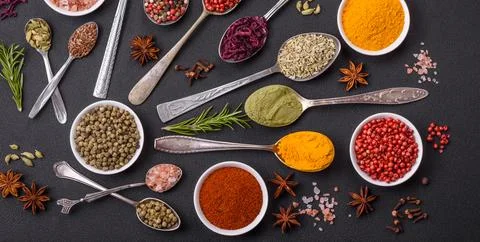 Composition consisting of variations of spices in white bowls and metal spoon Stock Photos