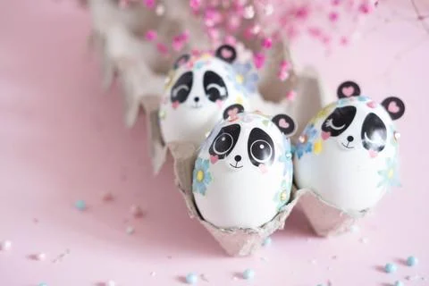 A composition with creatively colored Easter eggs with panda stickers and a b Stock Photos