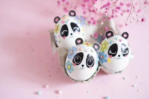A composition with creatively colored Easter eggs with panda stickers and a b Stock Photos