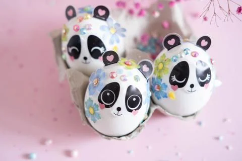 A composition with creatively colored Easter eggs with panda stickers and a b Stock Photos
