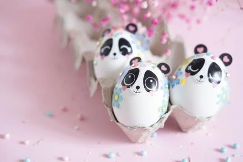 A composition with creatively colored Easter eggs with panda stickers and a b Stock Photos