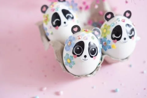 A composition with creatively colored Easter eggs with panda stickers and a Stock Photos