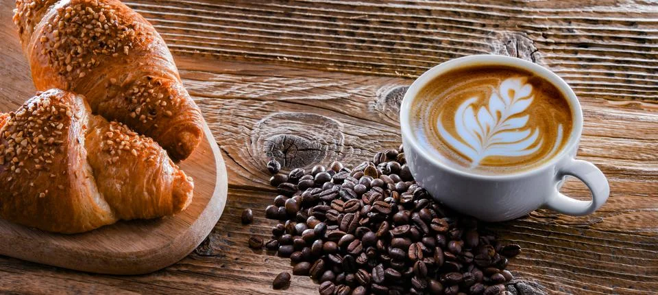 Composition with a cup of coffee and two croissants on an old wooden table Foto stock