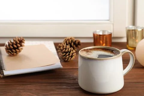 Composition with cup of hot coffee and notebooks on windowsill. Winter drink Fotos Stock