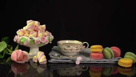 Composition cup of tea, macaroons, bouquet of flowers with falling marshmallow Stock Footage 156414869