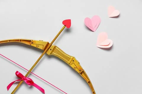 Composition with cupid's bow and paper hearts on grey background. Valentine's Stock Photos