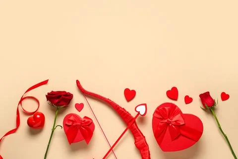 Composition cupid's bow, gift boxes and rose flowers on color background. Val Stock Photos